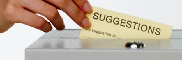 A female hand putting a suggestion into a suggestion box